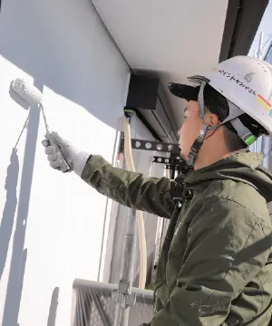外壁塗装（外壁をローラーで塗装する職人）
